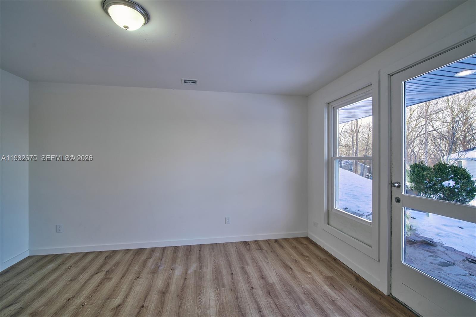189 McNamara Road Spring Valley, NY 10977 - Photo 37 of 47 an empty room with wooden floor and windows