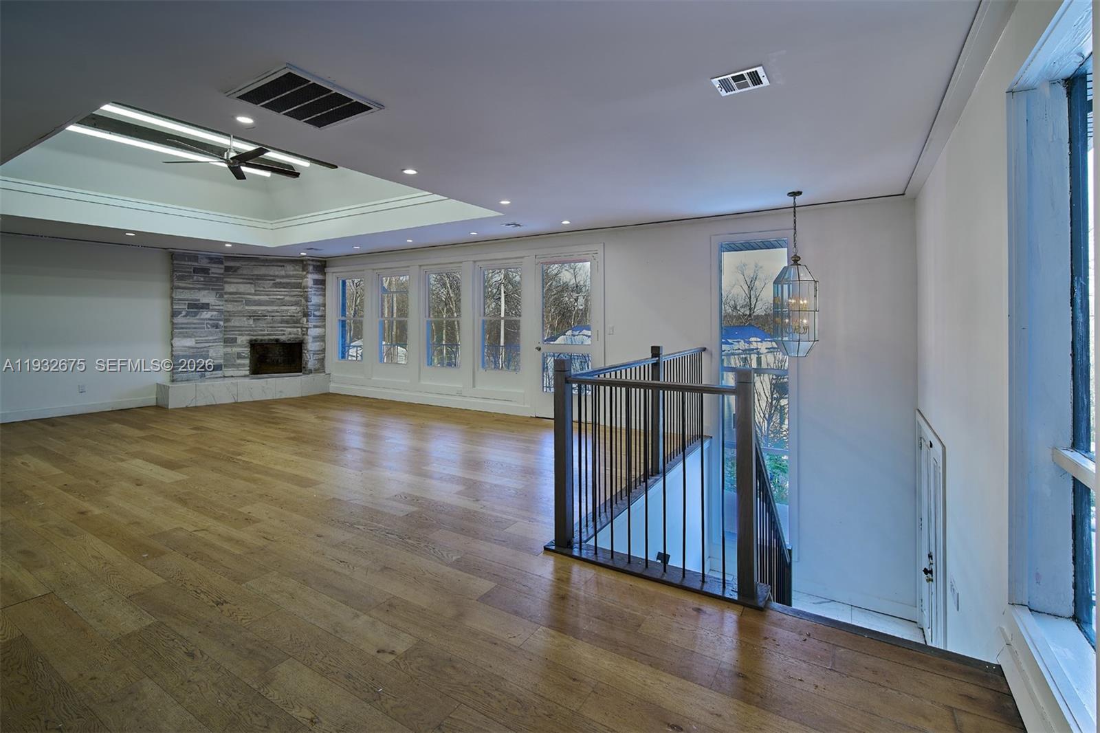 189 McNamara Road Spring Valley, NY 10977 - Photo 6 of 47 an empty room with wooden floor fireplace and windows