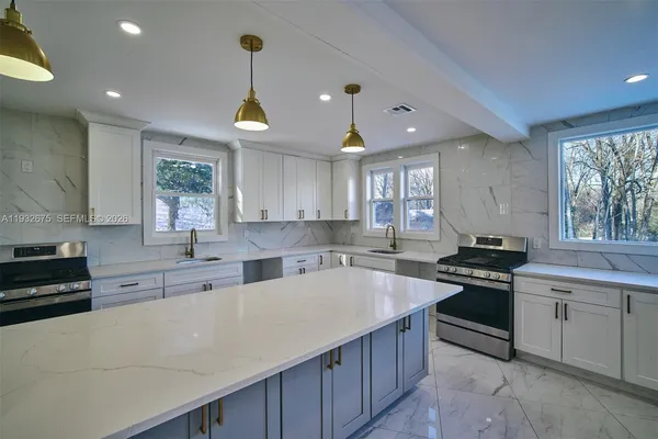 a kitchen with stainless steel appliances a sink stove and cabinets