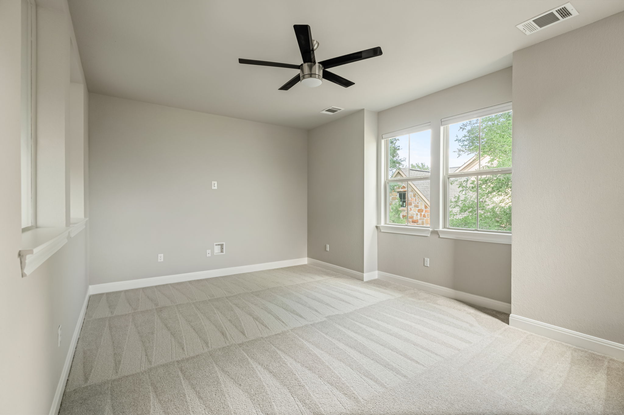 2516 Hopsack Mills Road Austin, TX 78748 - Photo 26 of 39 Spacious room featuring light-toned walls, patterned carpeting, multiple windows, a ceiling fan, and white trim throughout