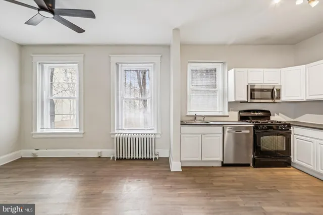 a kitchen with granite countertop a stove a sink and a microwave