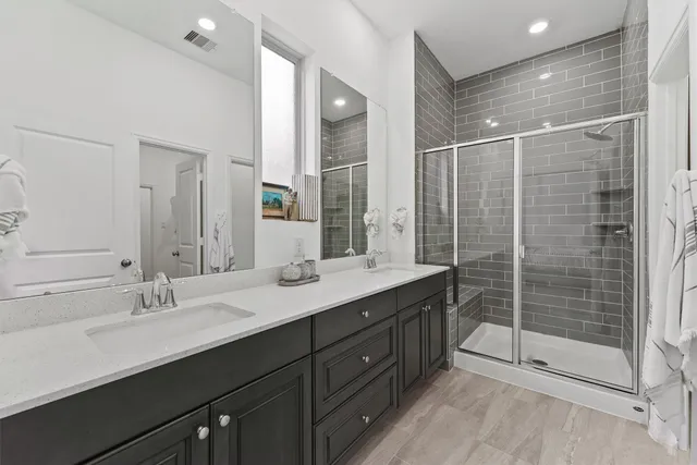 a bathroom with a shower sink and mirror