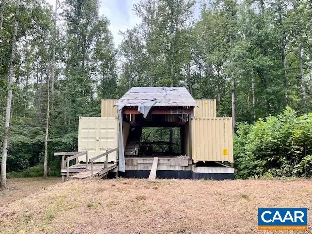 a view of a small house with yard and sitting area