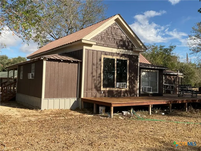 a backyard of a house with yard table and chairs