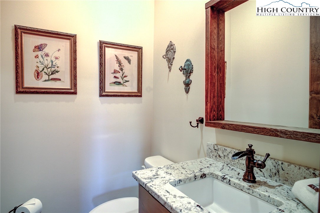 242 Camp Eagle Loop Banner Elk, NC 28604 - Photo 14 of 25 a bathroom with a granite countertop sink a toilet and a mirror