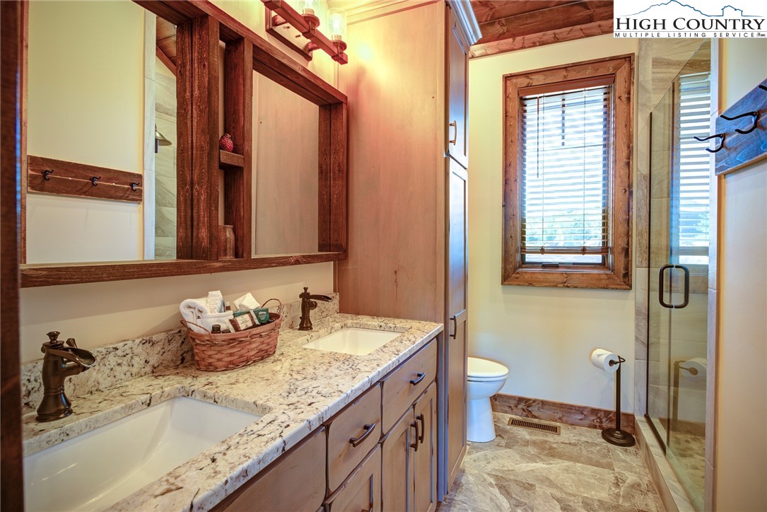 242 Camp Eagle Loop Banner Elk, NC 28604 - Photo 21 of 25 a bathroom with a granite countertop sink and a mirror