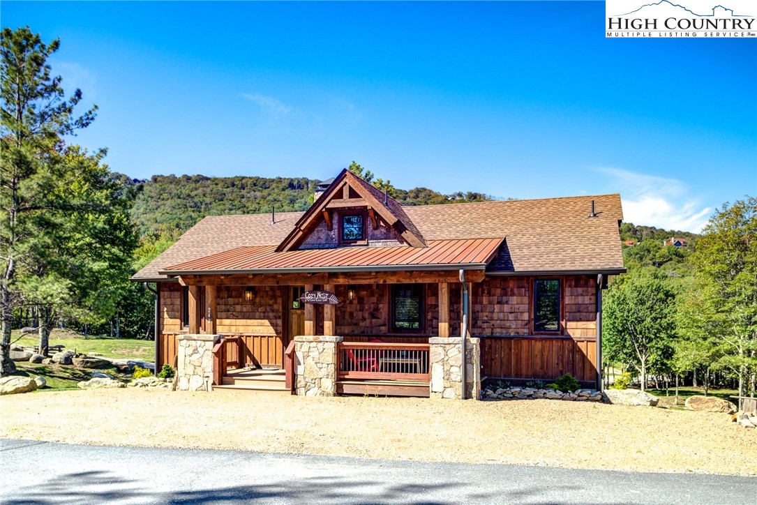 242 Camp Eagle Loop Banner Elk, NC 28604 - Photo 3 of 25 a view of a white house with large windows and a table and chairs