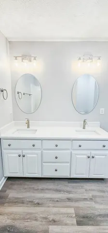 a spacious bathroom with a double vanity sink and a mirror