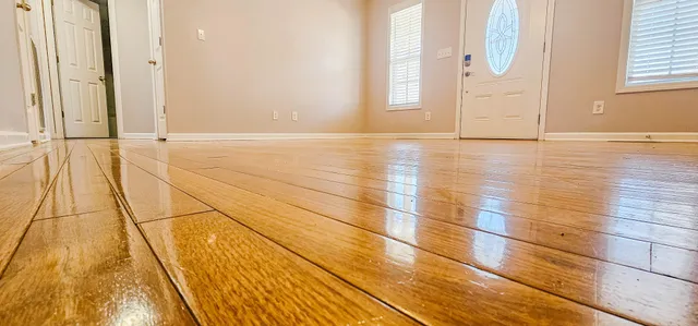 a view of empty room with wooden floor