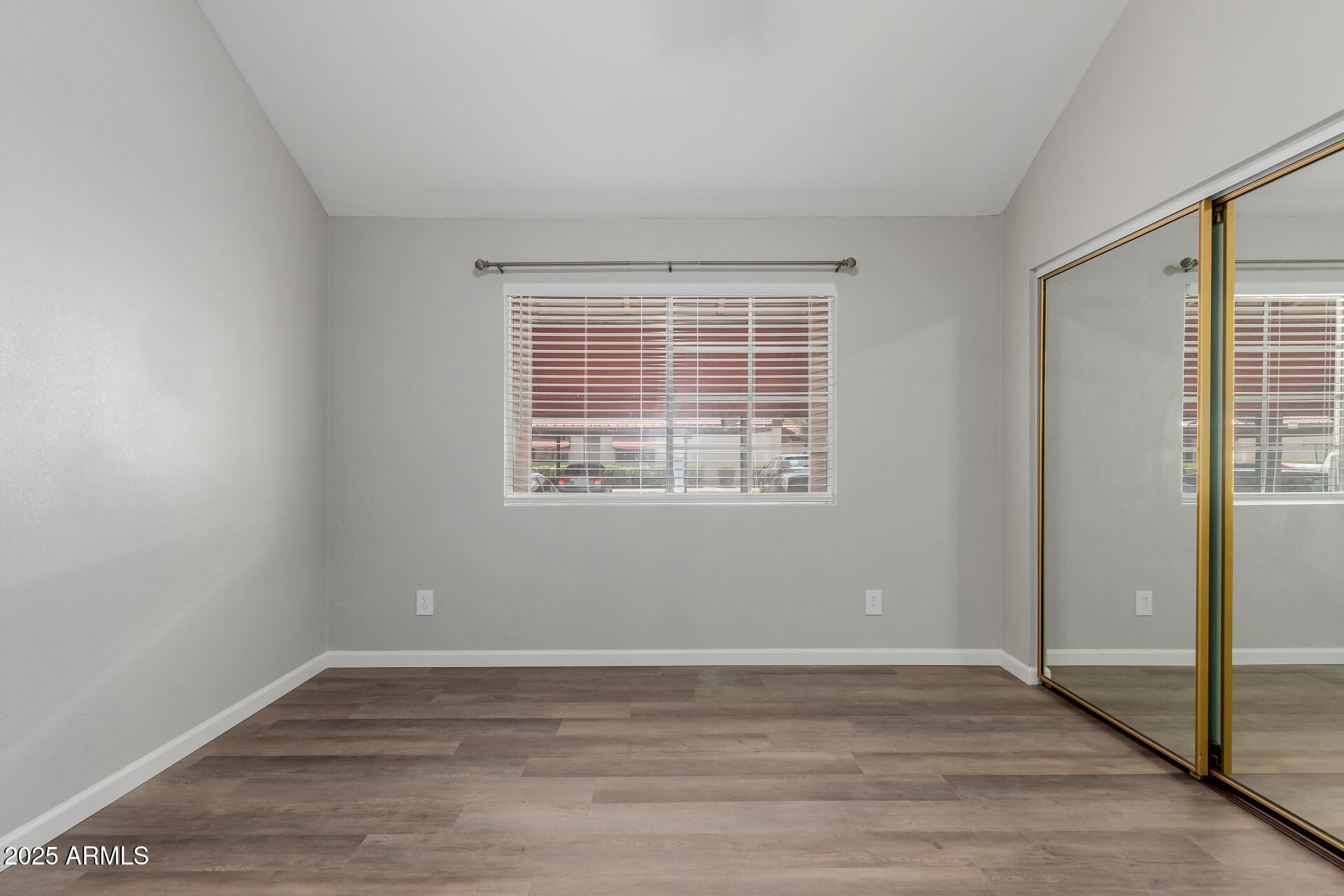 2144 East Center Lane, Unit 3 Tempe, AZ 85281 - Photo 12 of 30 a view of an empty room with wooden floor and a window