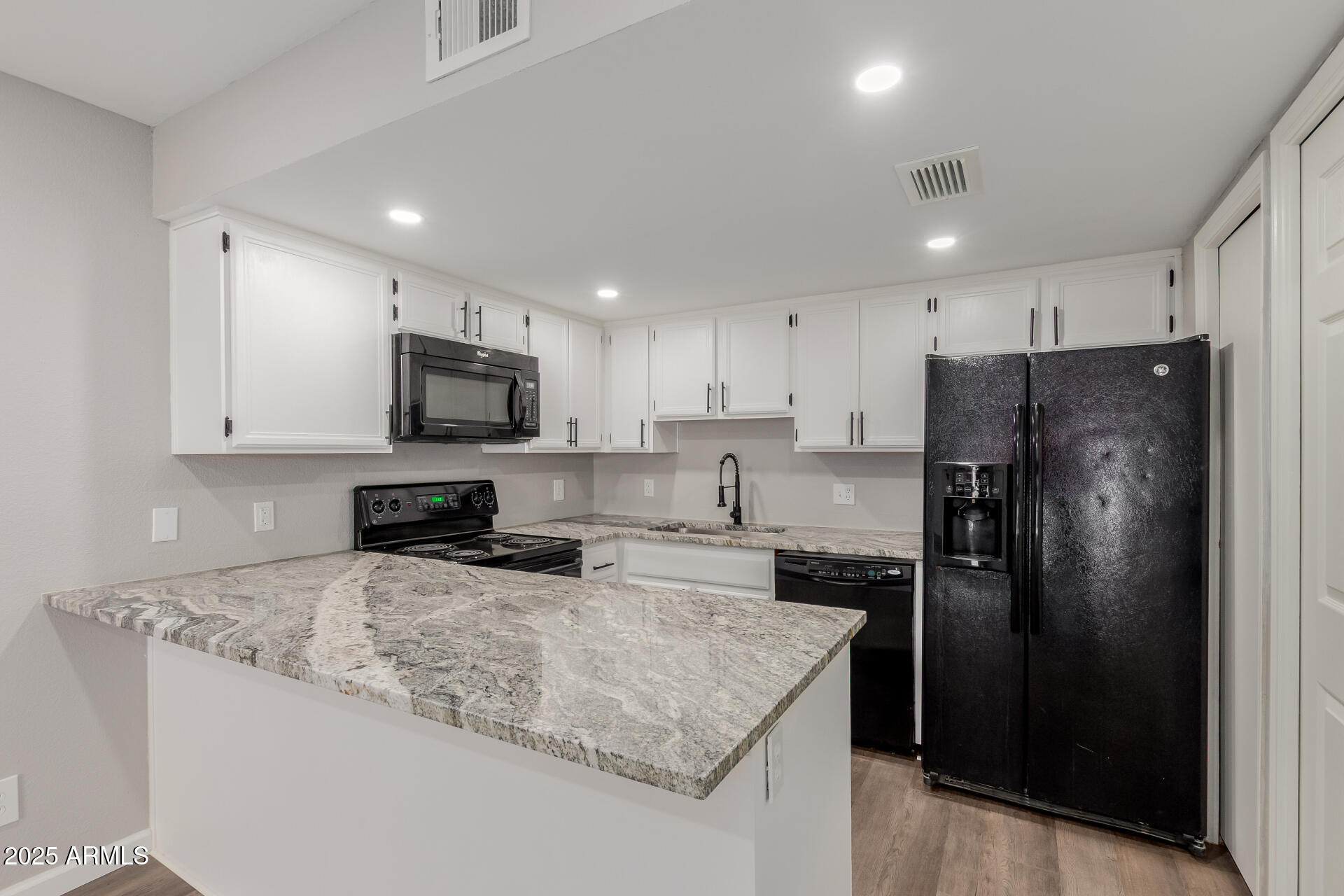 2144 East Center Lane, Unit 3 Tempe, AZ 85281 - Photo 4 of 30 a kitchen with granite countertop a refrigerator a sink a stove a microwave and cabinets