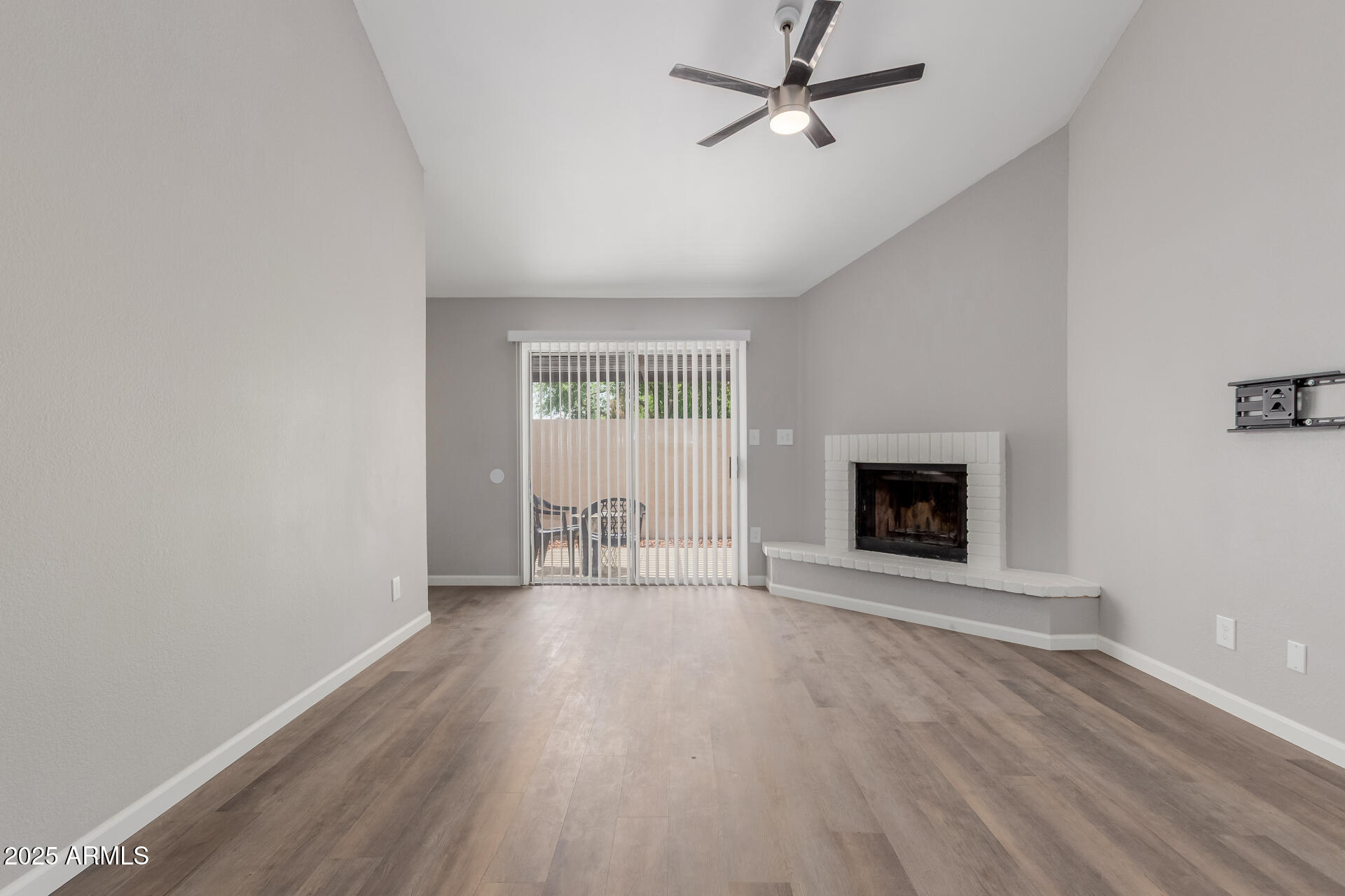 2144 East Center Lane, Unit 3 Tempe, AZ 85281 - Photo 9 of 30 an empty room with wooden floor a fireplace and windows