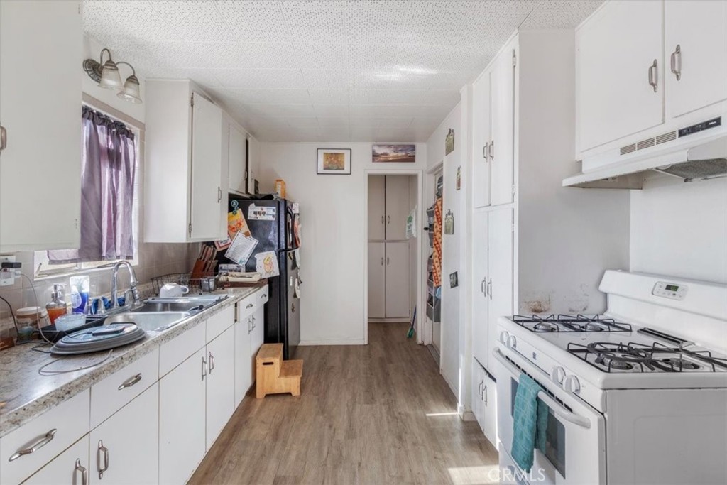 13645 Gilbert Street North Edwards, CA 93523 - Photo 2 of 12 a kitchen with stainless steel appliances granite countertop a stove and a sink