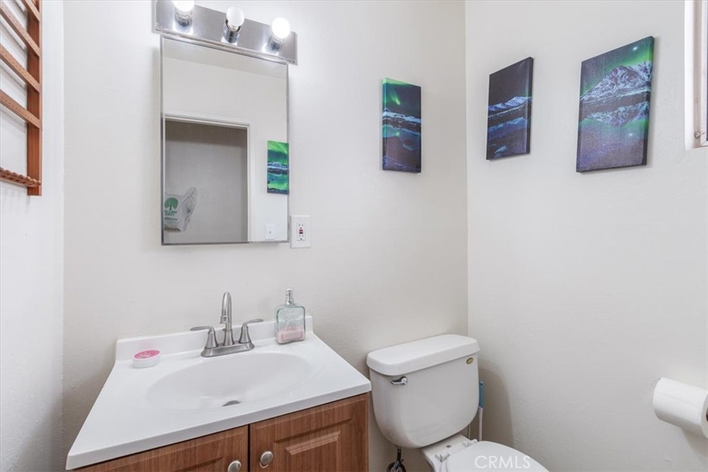 13645 Gilbert Street North Edwards, CA 93523 - Photo 10 of 12 a bathroom with a toilet sink and mirror