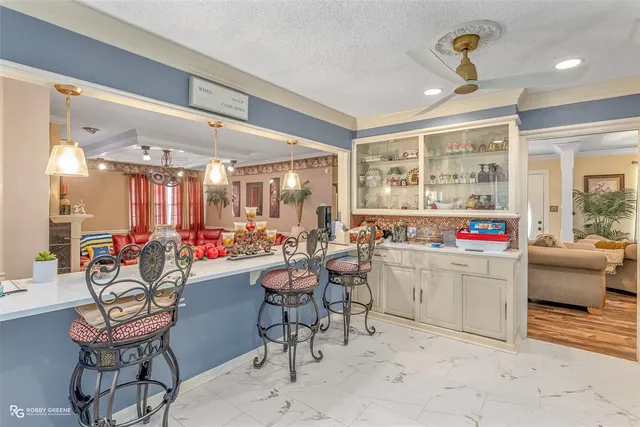 a very nice looking open dining room with kitchen island granite countertop a sink and a refrigerator