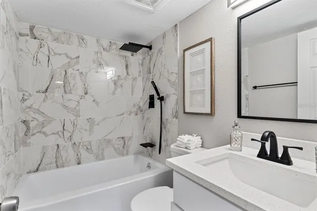 a bathroom with a sink vanity mirror and a bathtub