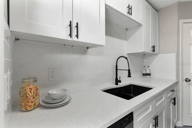 a kitchen with a sink a stove and cabinets
