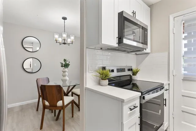 a kitchen with a table chairs and chandelier