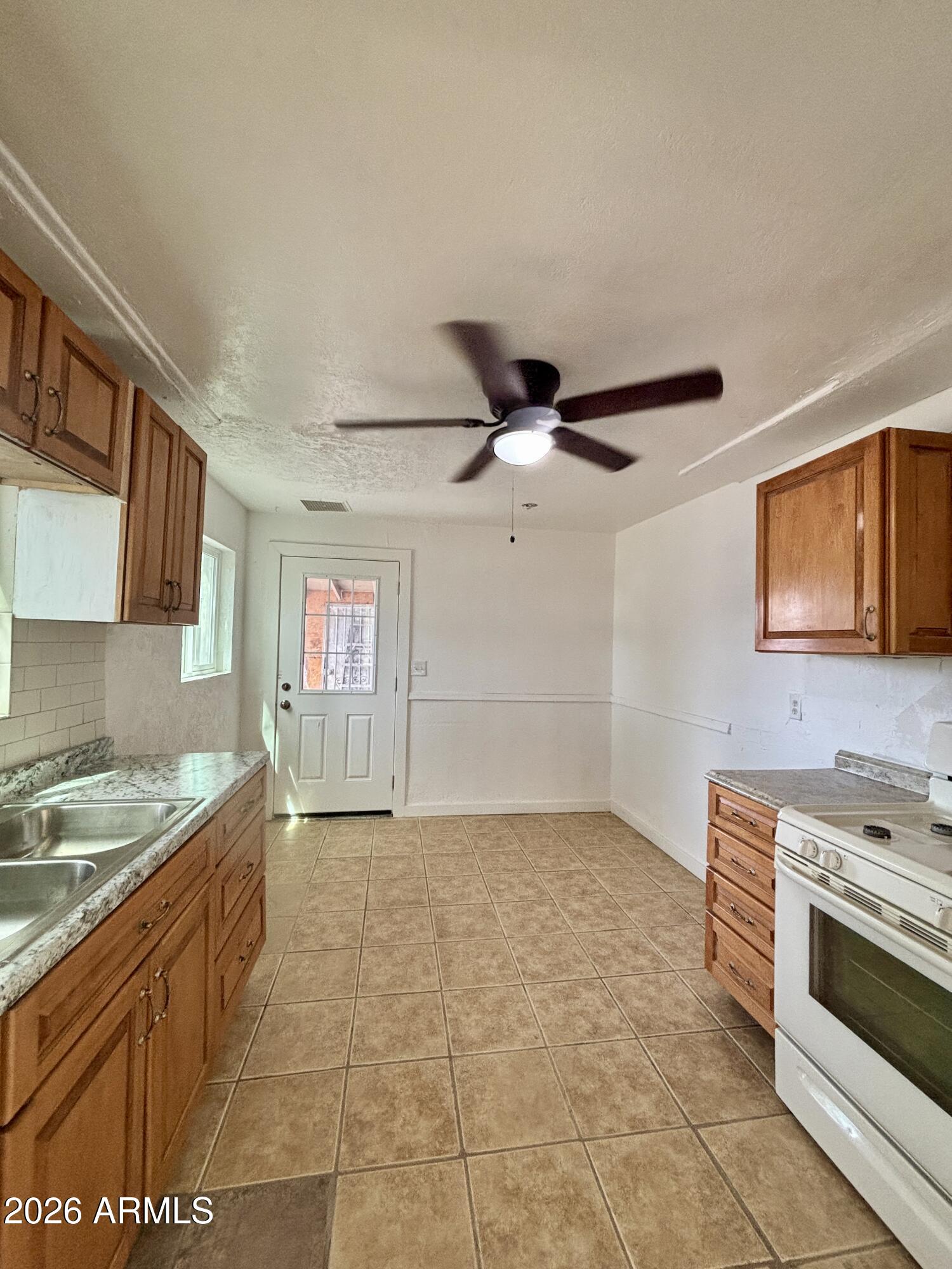 3036 West Almeria Road Phoenix, AZ 85009 - Photo 2 of 18 a kitchen with a stove a sink and a refrigerator