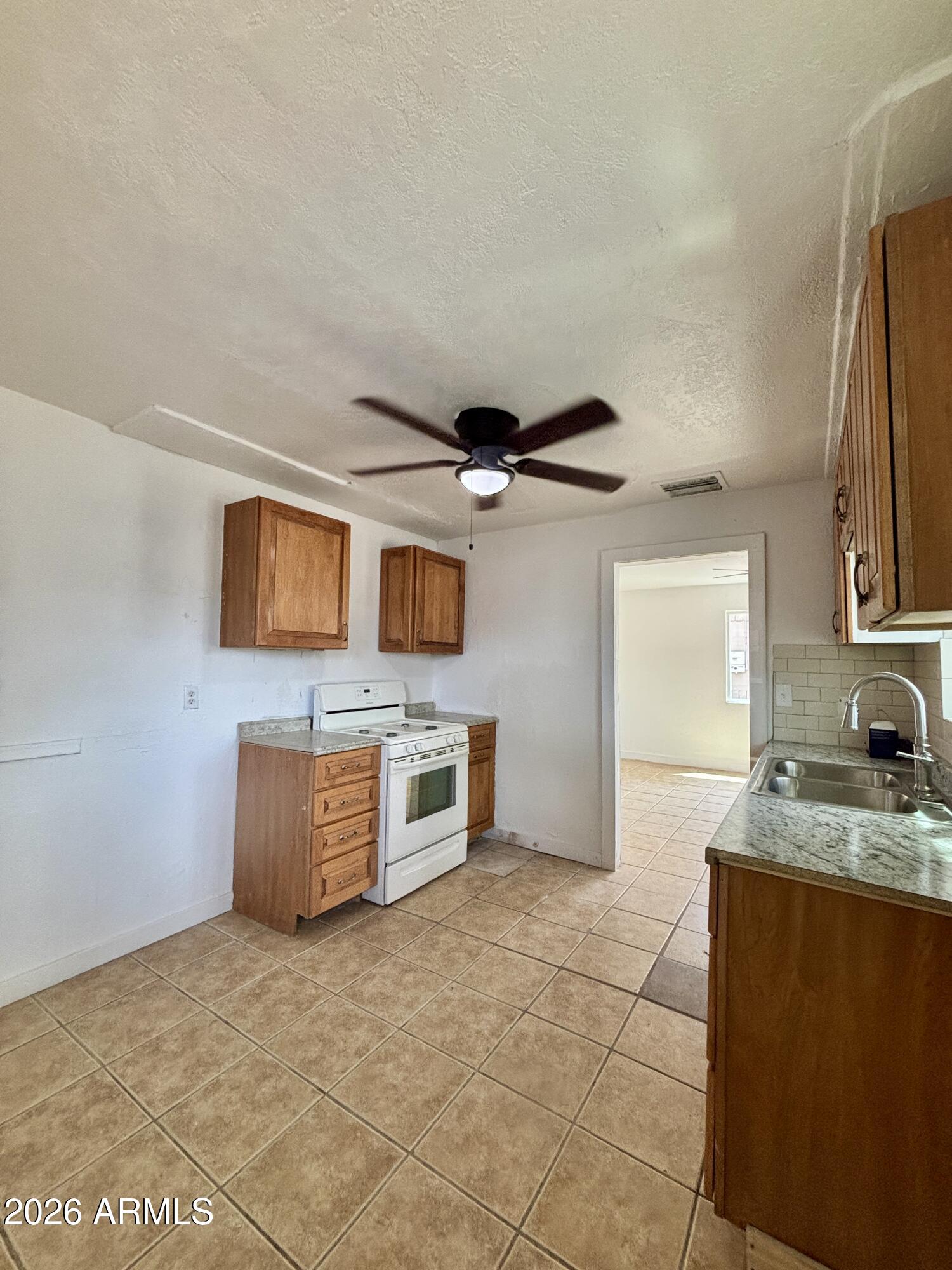 3036 West Almeria Road Phoenix, AZ 85009 - Photo 3 of 18 a kitchen with stainless steel appliances granite countertop a sink and a stove top oven