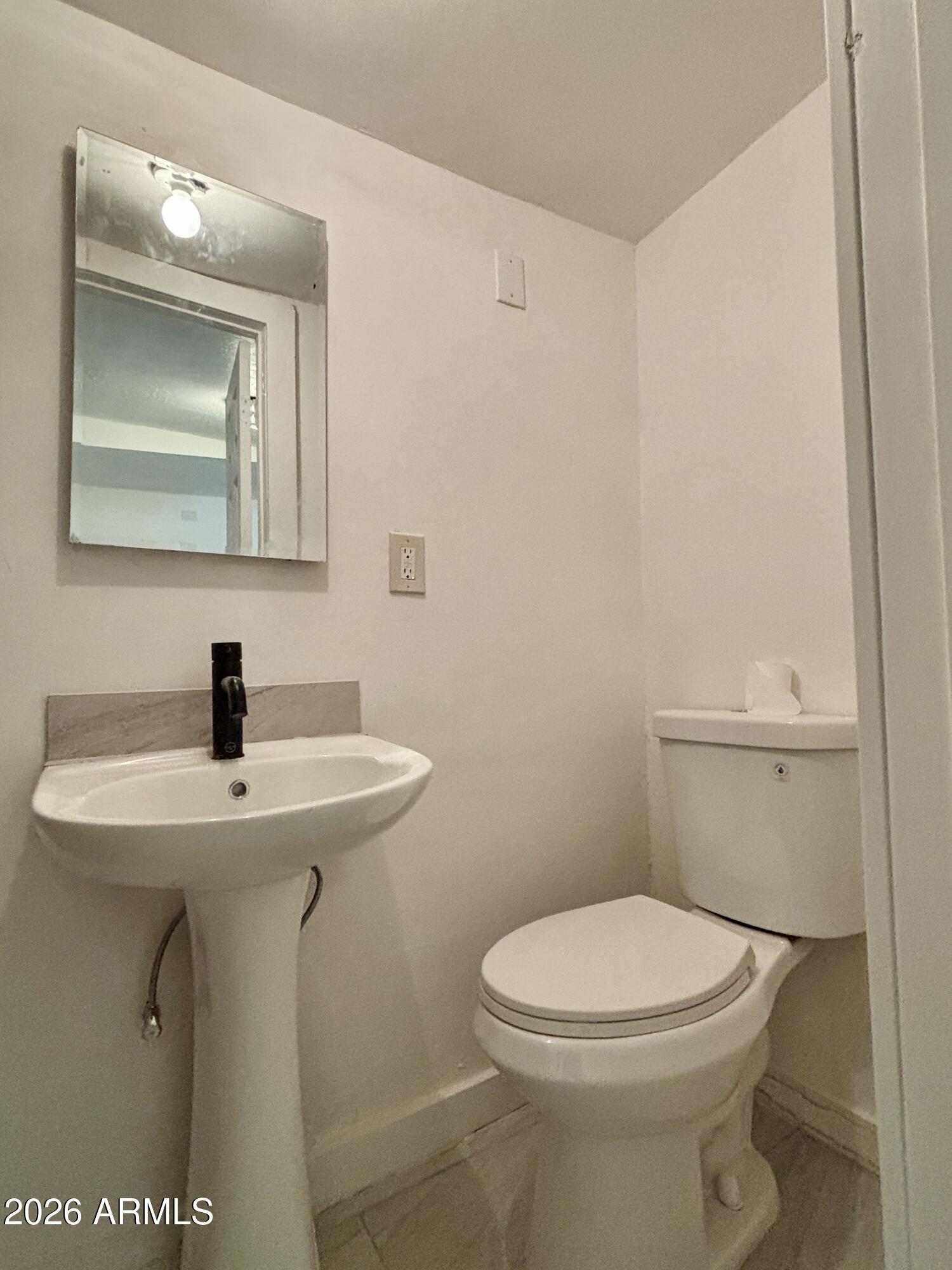 3036 West Almeria Road Phoenix, AZ 85009 - Photo 4 of 18 a bathroom with a sink a toilet and mirror