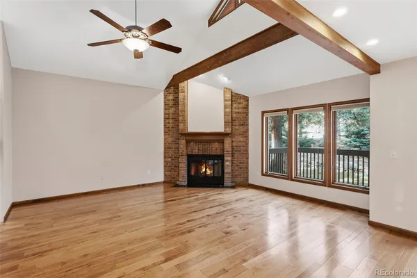 a view of an empty room with a fireplace and a window