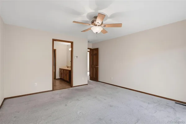 an empty room with closet and a chandelier fan