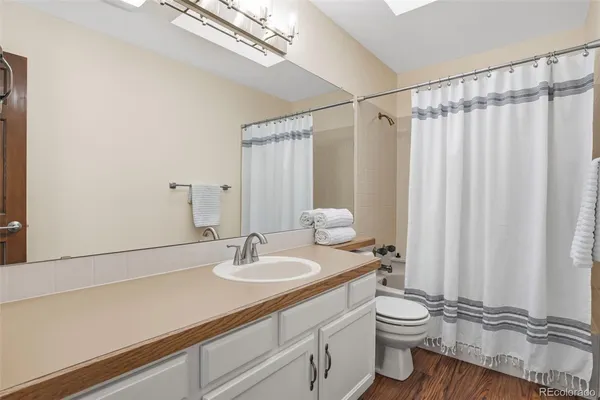 a bathroom with a sink a toilet and shower curtain