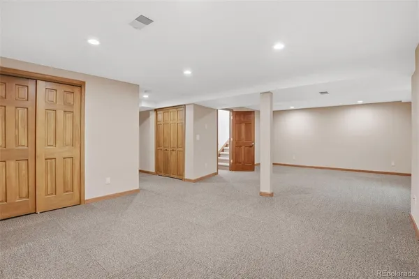 an empty room with a cabinet and mirrors