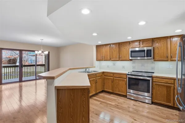 a kitchen with stainless steel appliances granite countertop a stove a sink and a microwave