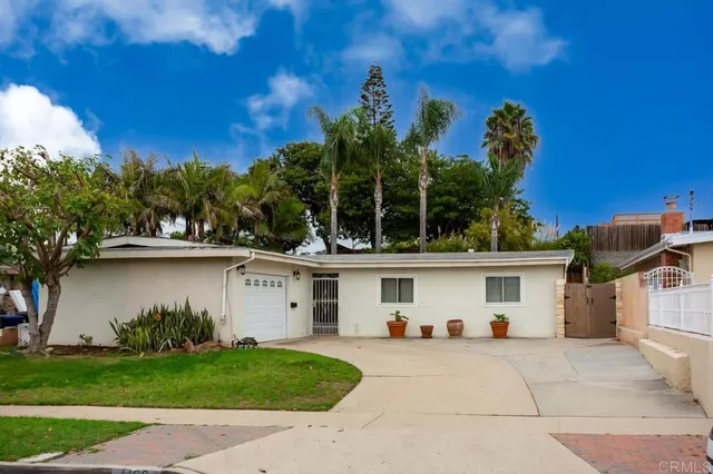 a view of a white house with a yard and a large tree