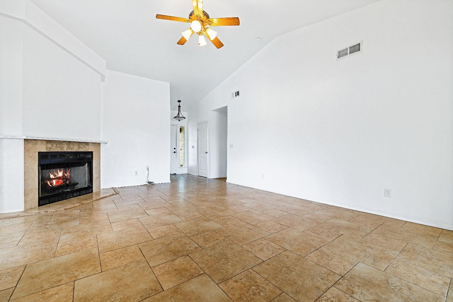 21596 Road 30 Madera, CA 93638 - Photo 12 of 57 a view of an empty room with a ceiling fan and fire place