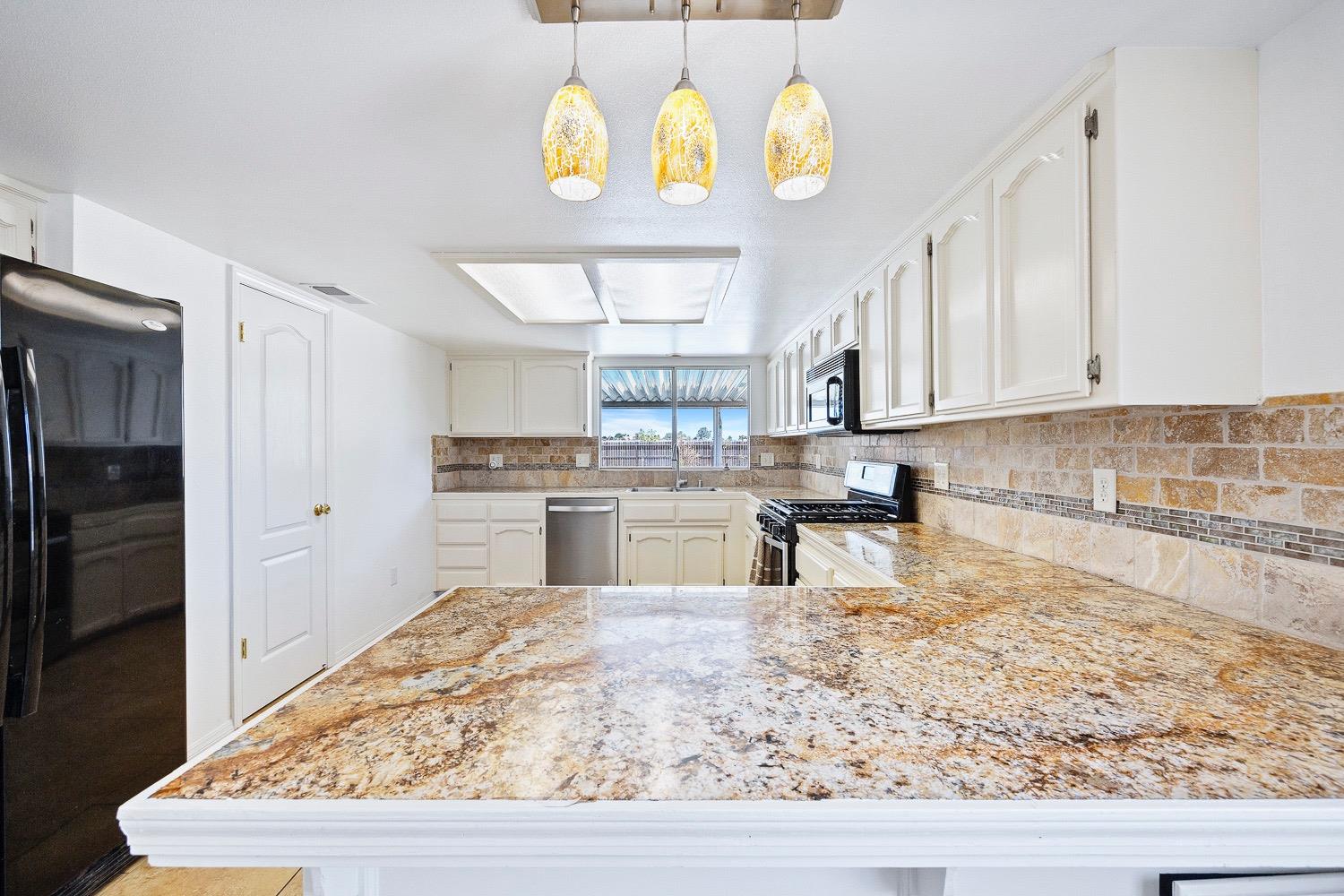 21596 Road 30 Madera, CA 93638 - Photo 26 of 57 a kitchen with stainless steel appliances granite countertop a sink dishwasher stove and refrigerator with wooden floor