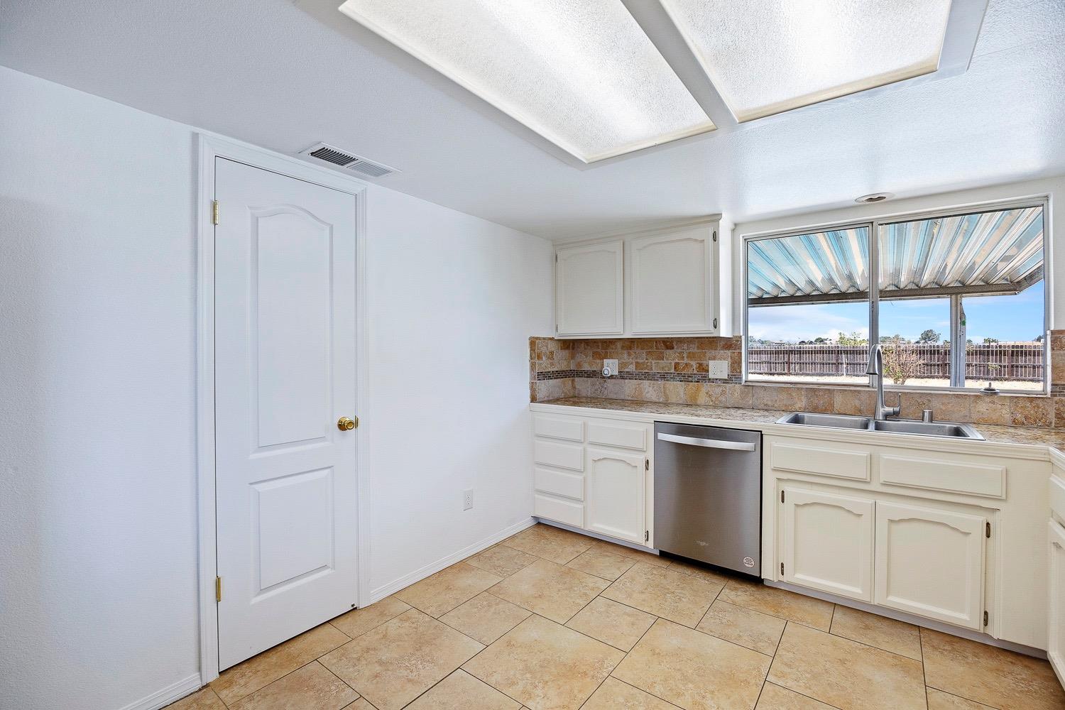 21596 Road 30 Madera, CA 93638 - Photo 28 of 57 a kitchen with white cabinets a sink and dishwasher
