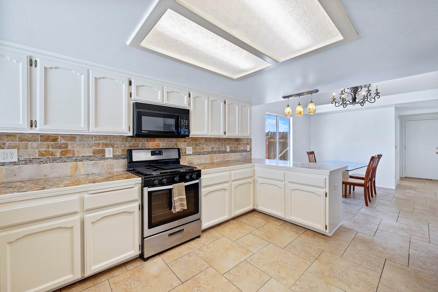 21596 Road 30 Madera, CA 93638 - Photo 30 of 57 a kitchen with stainless steel appliances granite countertop a stove and a sink