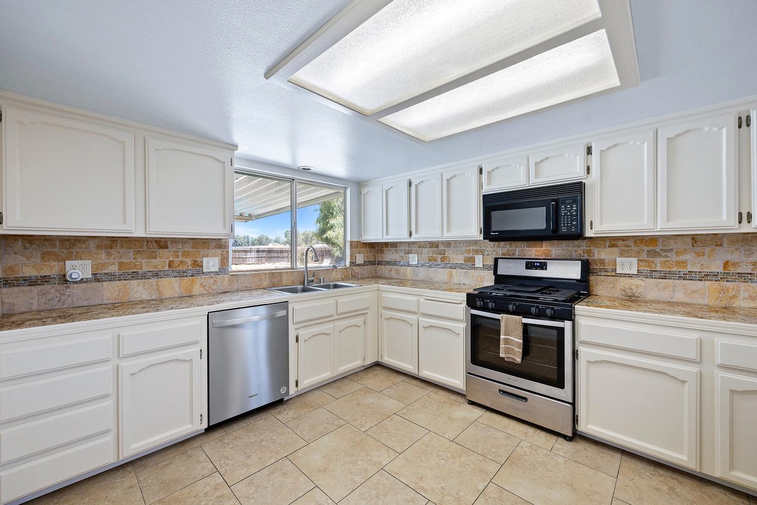 21596 Road 30 Madera, CA 93638 - Photo 31 of 57 a kitchen with white cabinets appliances and a sink