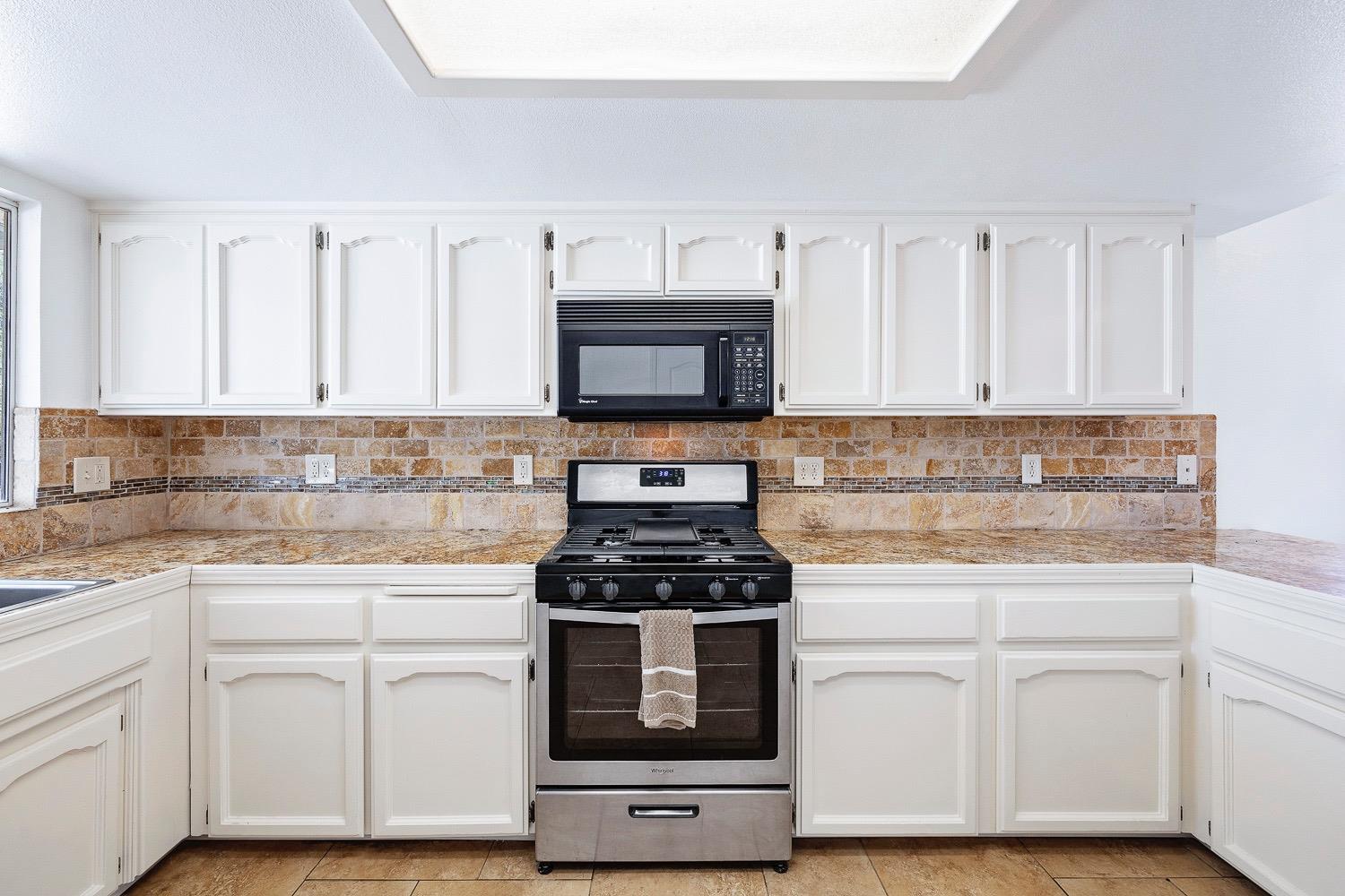 21596 Road 30 Madera, CA 93638 - Photo 33 of 57 a kitchen with white cabinets and appliances