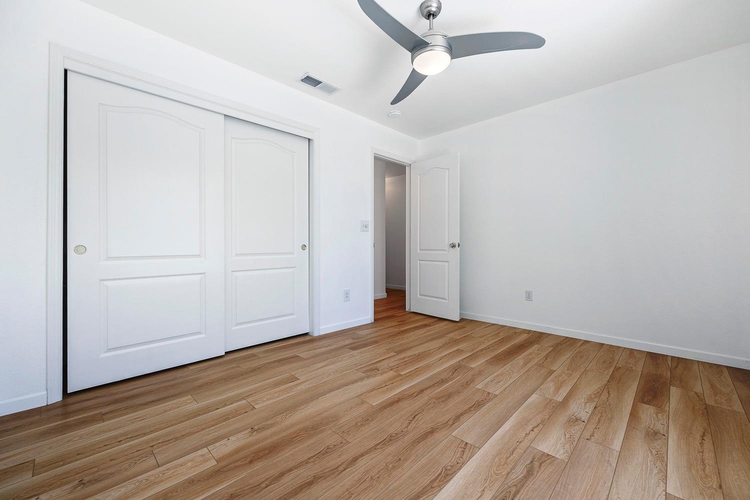 21596 Road 30 Madera, CA 93638 - Photo 40 of 57 an empty room with wooden floor and windows