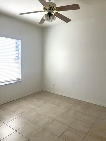 an empty room with fan and entrance