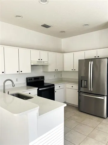 a kitchen with white cabinets and stainless steel appliances