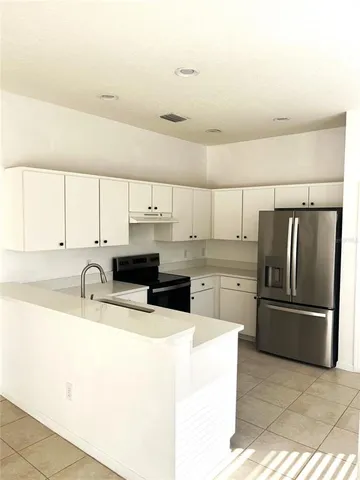 a kitchen with stainless steel appliances a sink a counter top space cabinets and a window