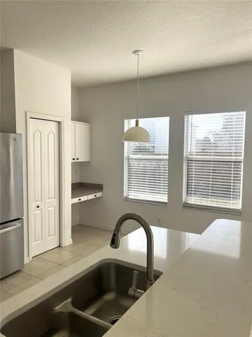 a kitchen with a refrigerator a sink and chandelier