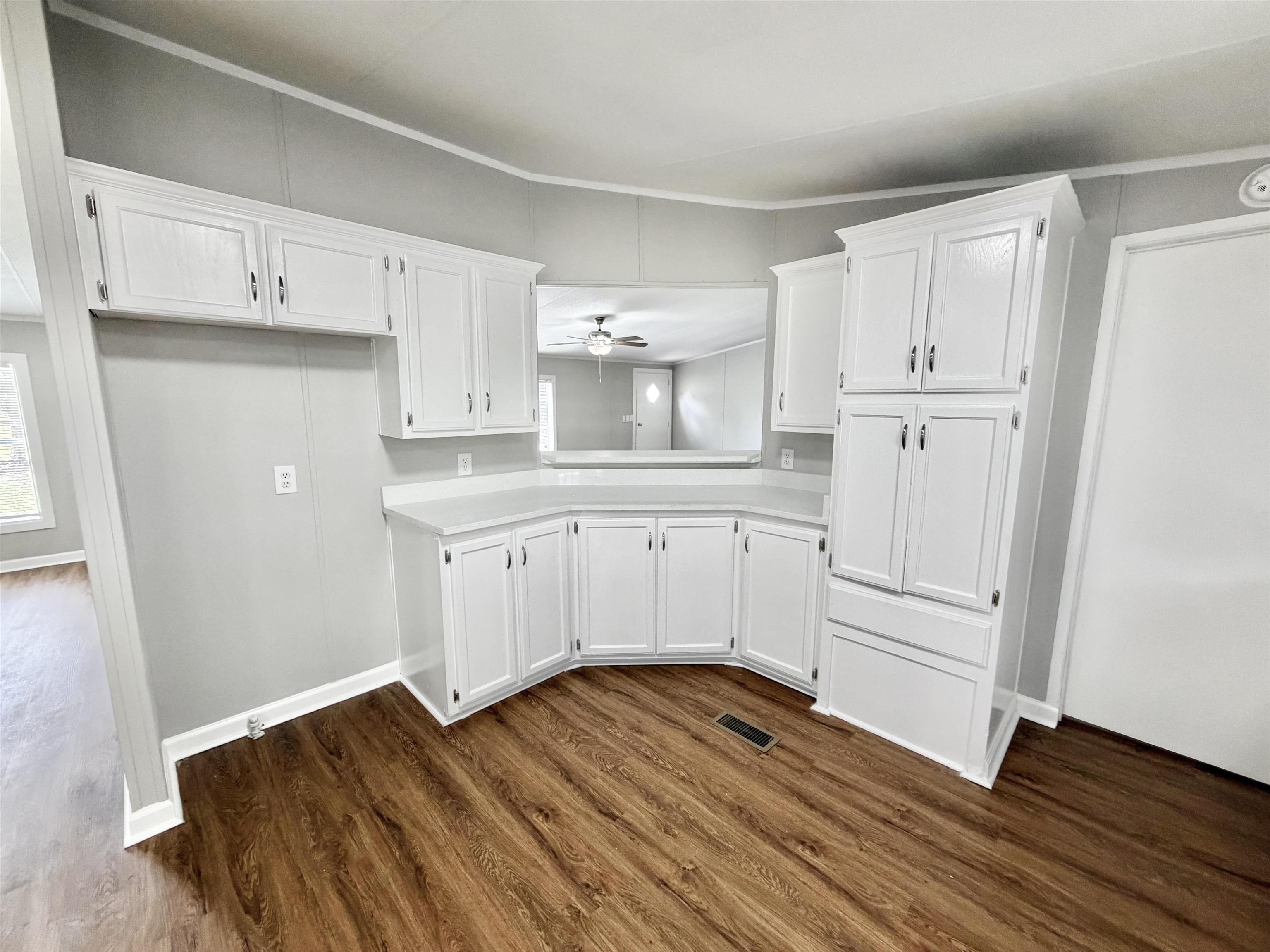 1655 Fayne Road Brighton, TN 38011 - Photo 8 of 28 Kitchen area featuring white cabinetry, light-toned countertops, and wood-finish flooring