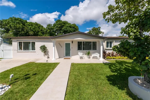 a front view of house with yard and green space
