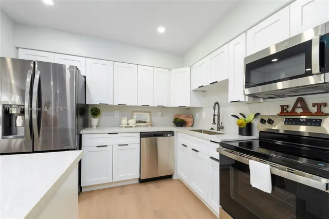 a kitchen with stainless steel appliances a sink stove and refrigerator
