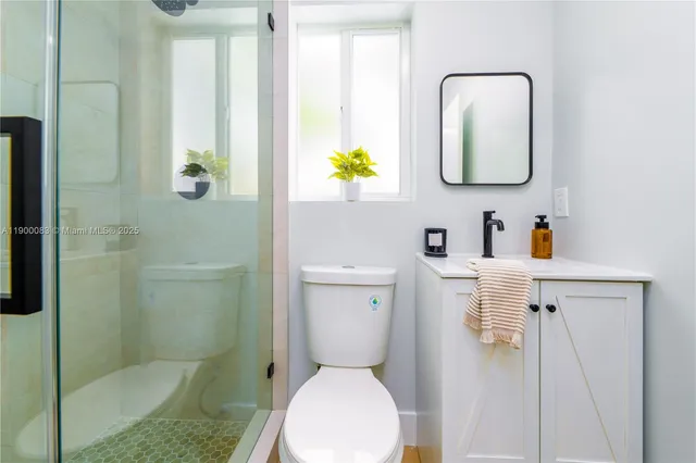 a bathroom with a toilet sink vanity and mirror