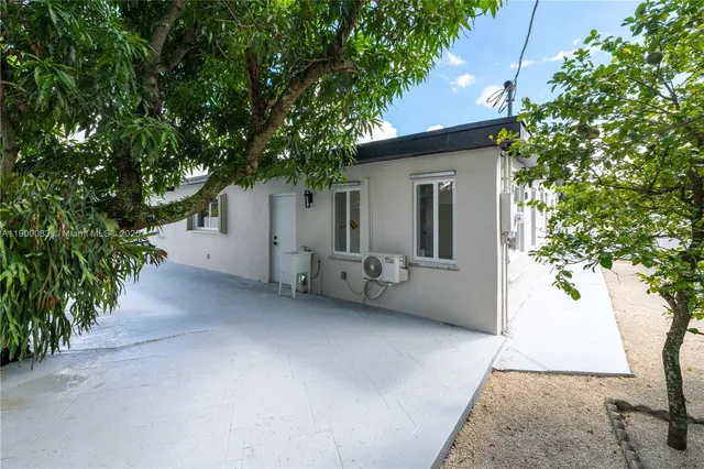 a view of a house with a cars park side of a road