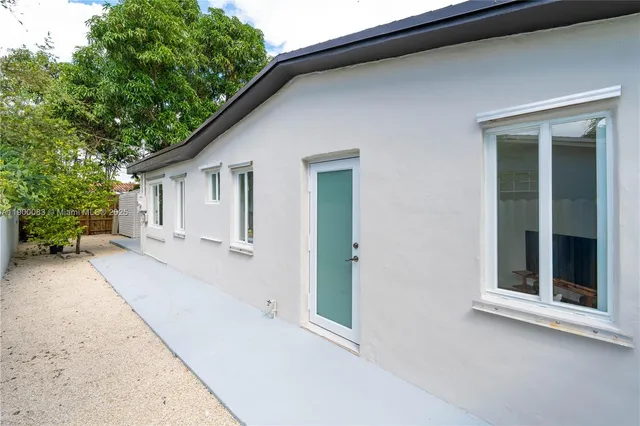 a view of house with backyard and glass windows
