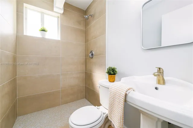 a bathroom with a sink a toilet and shower