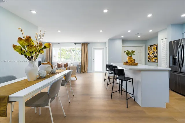 a dining room filled chandelier and wooden floor